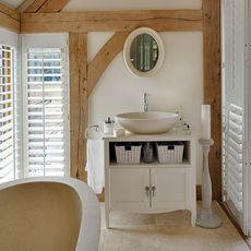 white bathroom with wooden beams and bathtub