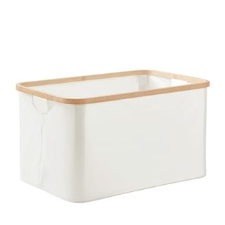 A white fabric laundry basket with a solid bamboo trim around the top