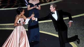 Regina King presents an Oscar award to Brad Pitt.