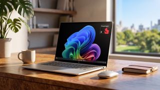 A laptop displaying a colorful wave pattern on the screen sits on a wooden desk beside a mouse, a notebook, and a cup. A window reveals a lush, sunny view.