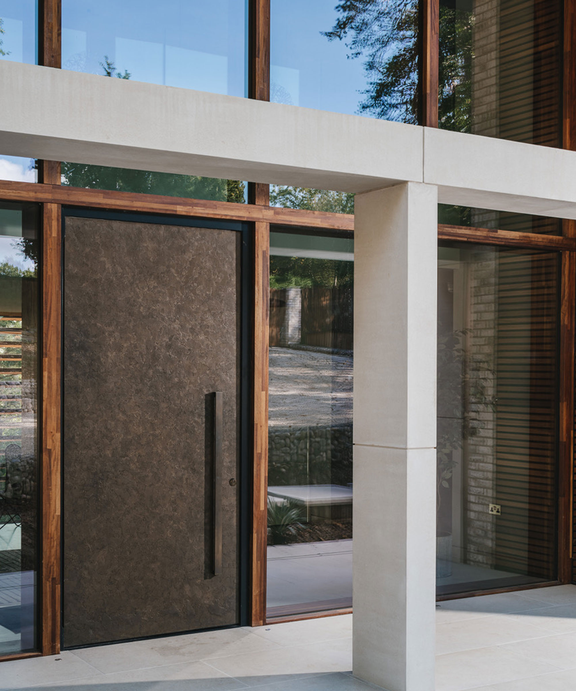 modern white open porch with oversized bronze front door
