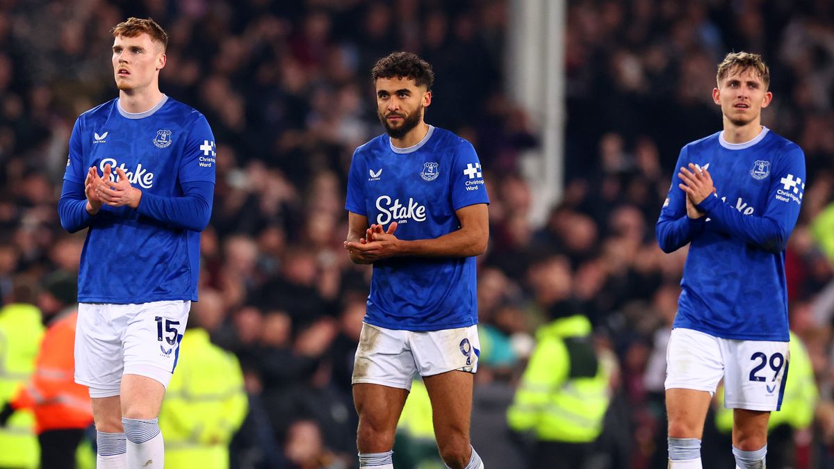 Three Everton players applaud the crowd at the end of a Premier League game