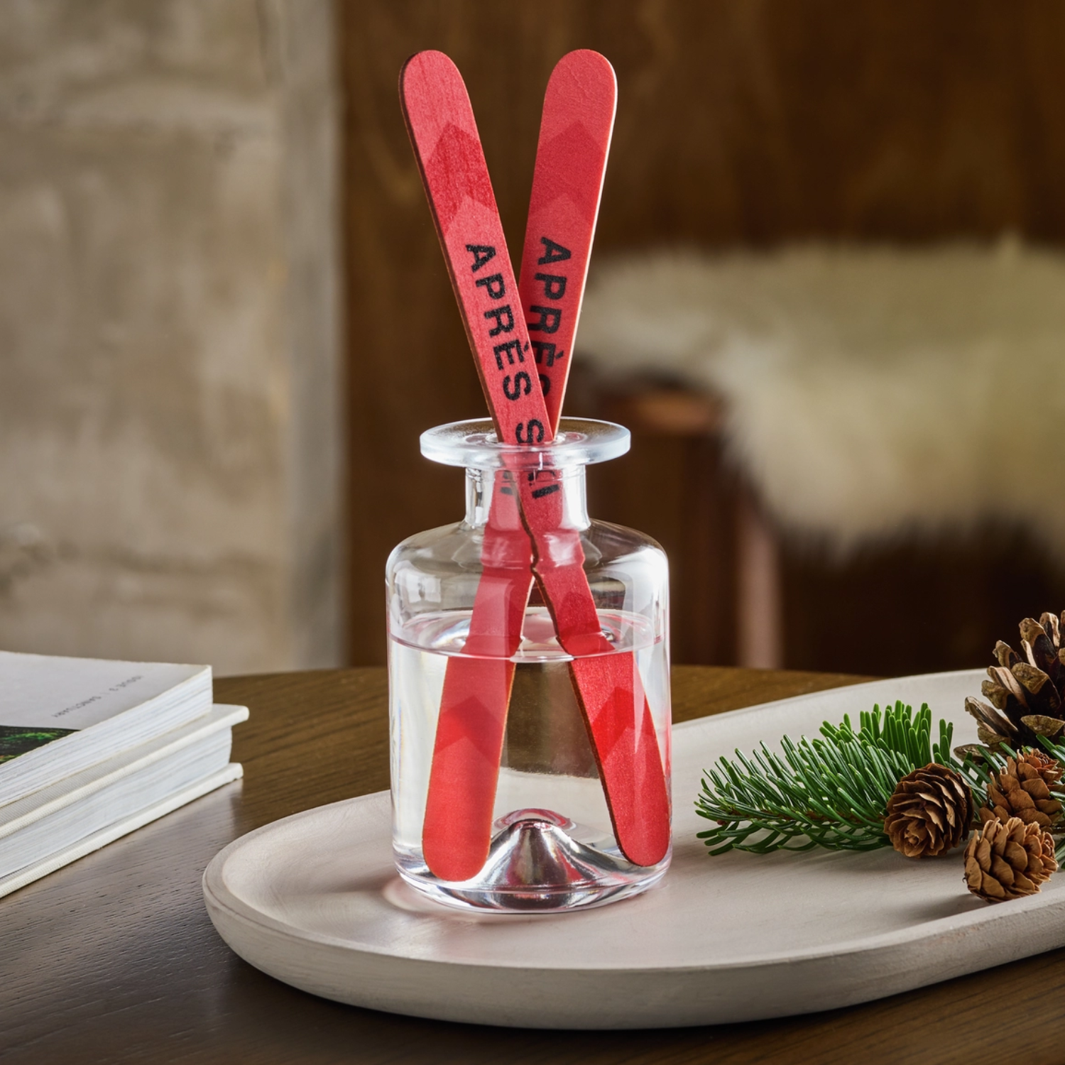 A glass vessel with essential oil and ski shaped reeds