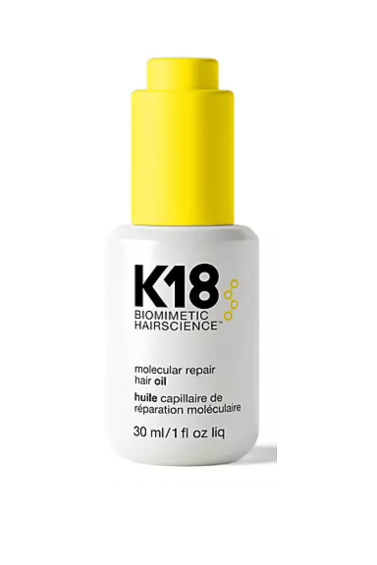 A white and yellow bottle of hair oil with black lettering
