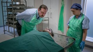 Tony Manning (Daniel Ryan) inspects Saif's body in 'The Bay' season 3.