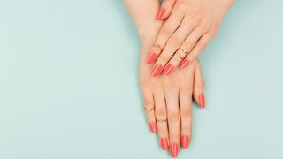 Hands with coral nail polish