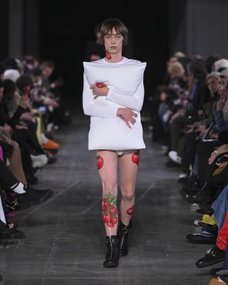 JW Anderson runway with model holding white pillow