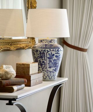 Close up of table lamp on console table in modern entryway