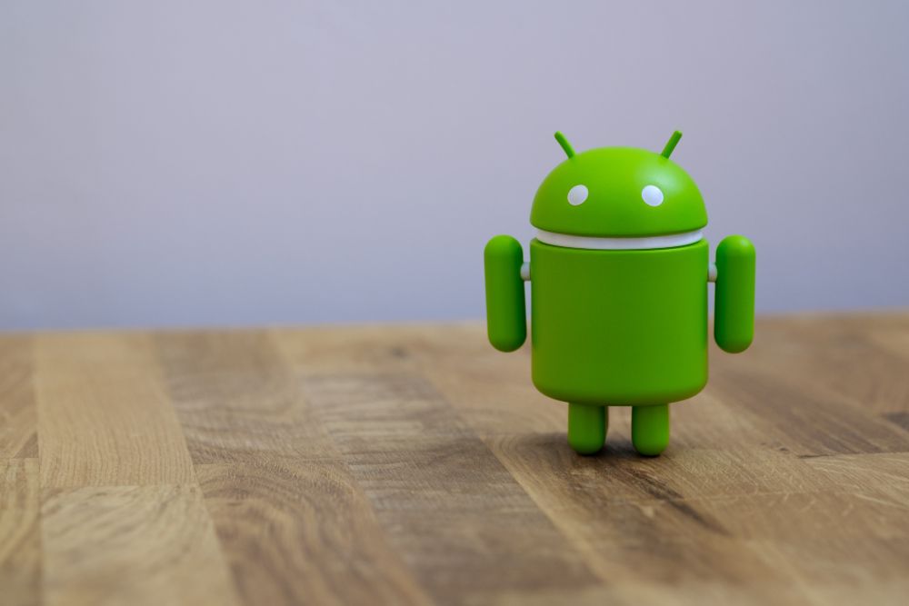 A Google Android figurine stood on a wooden table