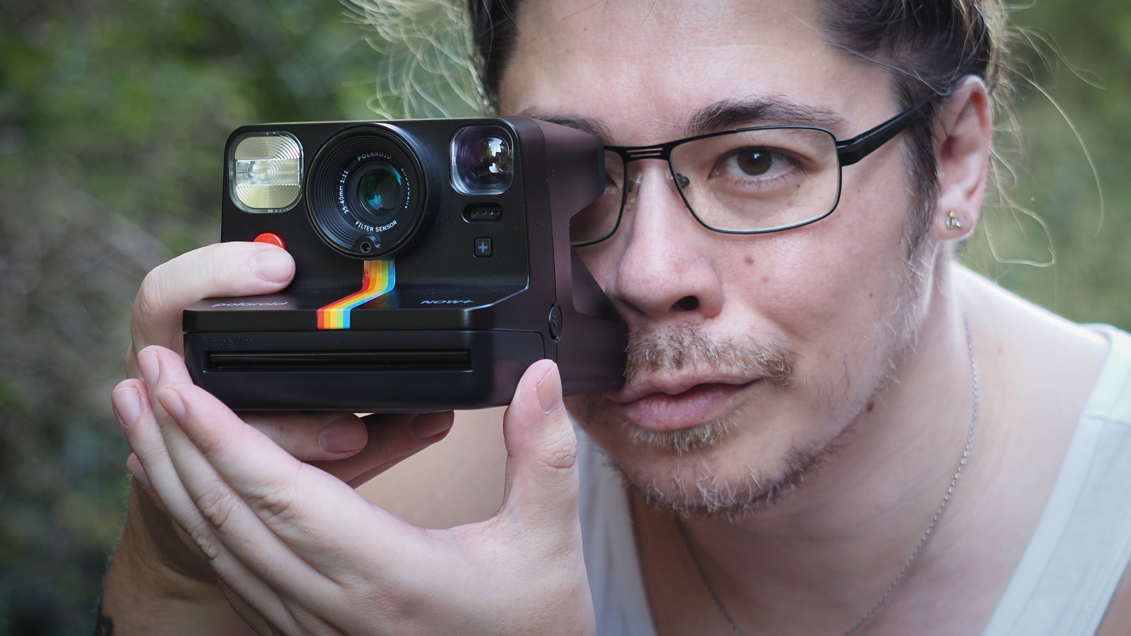 James Artaius holding a Polaroid Now+ Generation 2 in a woodland setting