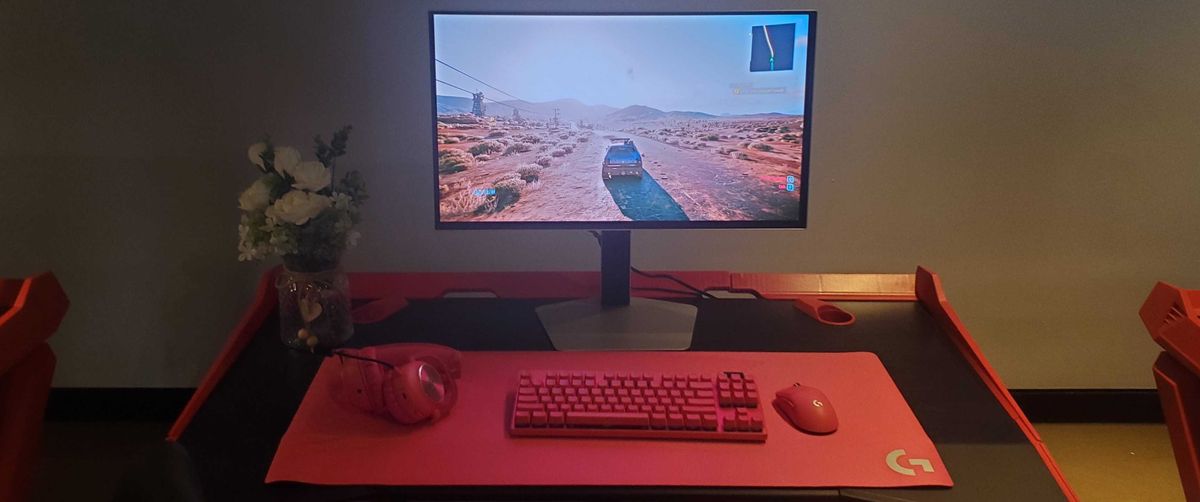 gaming monitor near pink keyboard