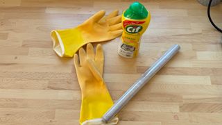 Rubber gloves, Cif and cling wrap on a surface