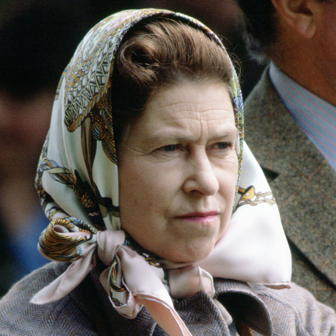 Queen Elizabeth wearing a head scarf and an angry expression