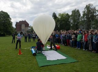 Students gather to watch researchers prepare the Small Photon-Entangling Quantum System for a test launch aboard a weather balloon at a field near Heinrich-Suso-Gymnasium Konstanz in Germany.