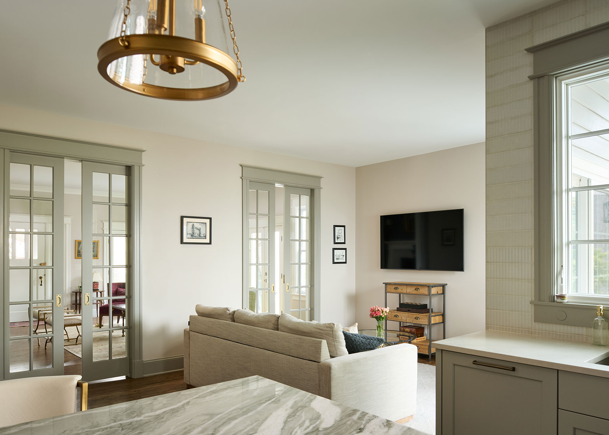 open plan kitchen dining and living room with glass sliding doors leading to a separate sitting room