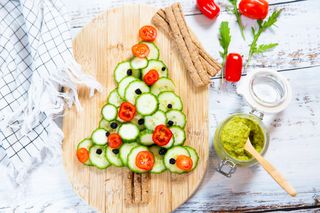 Vegetable salad with tomatoes, cucumber and olives. Christmas tree shape.