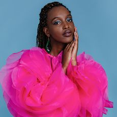 model wearing blue eyeshadow and a pink jacket