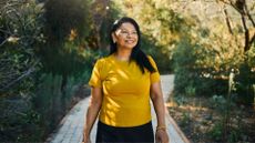 Woman walking along path in sunshine