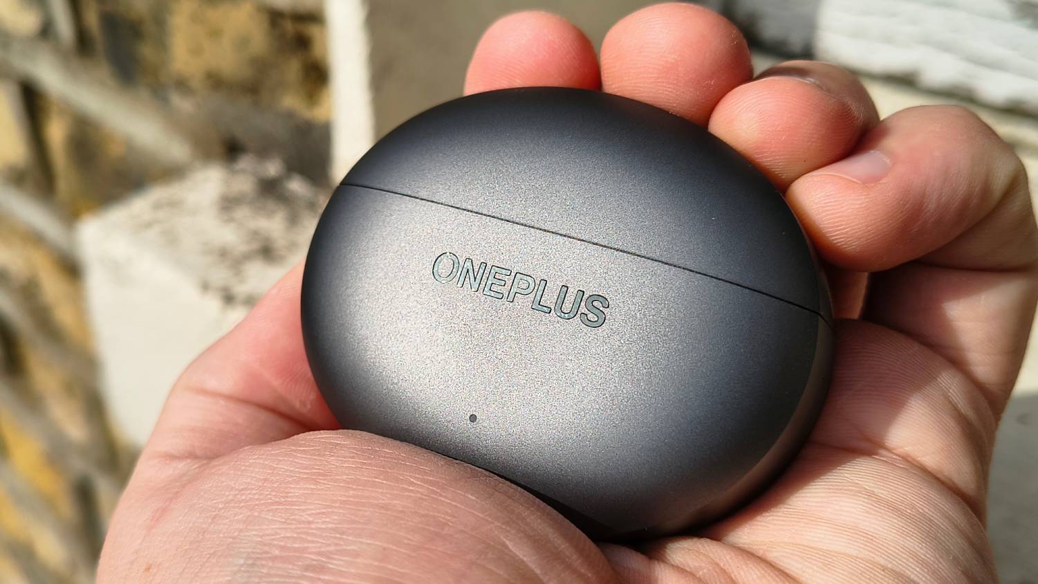 The OnePlus Buds 4 in a man's hands.