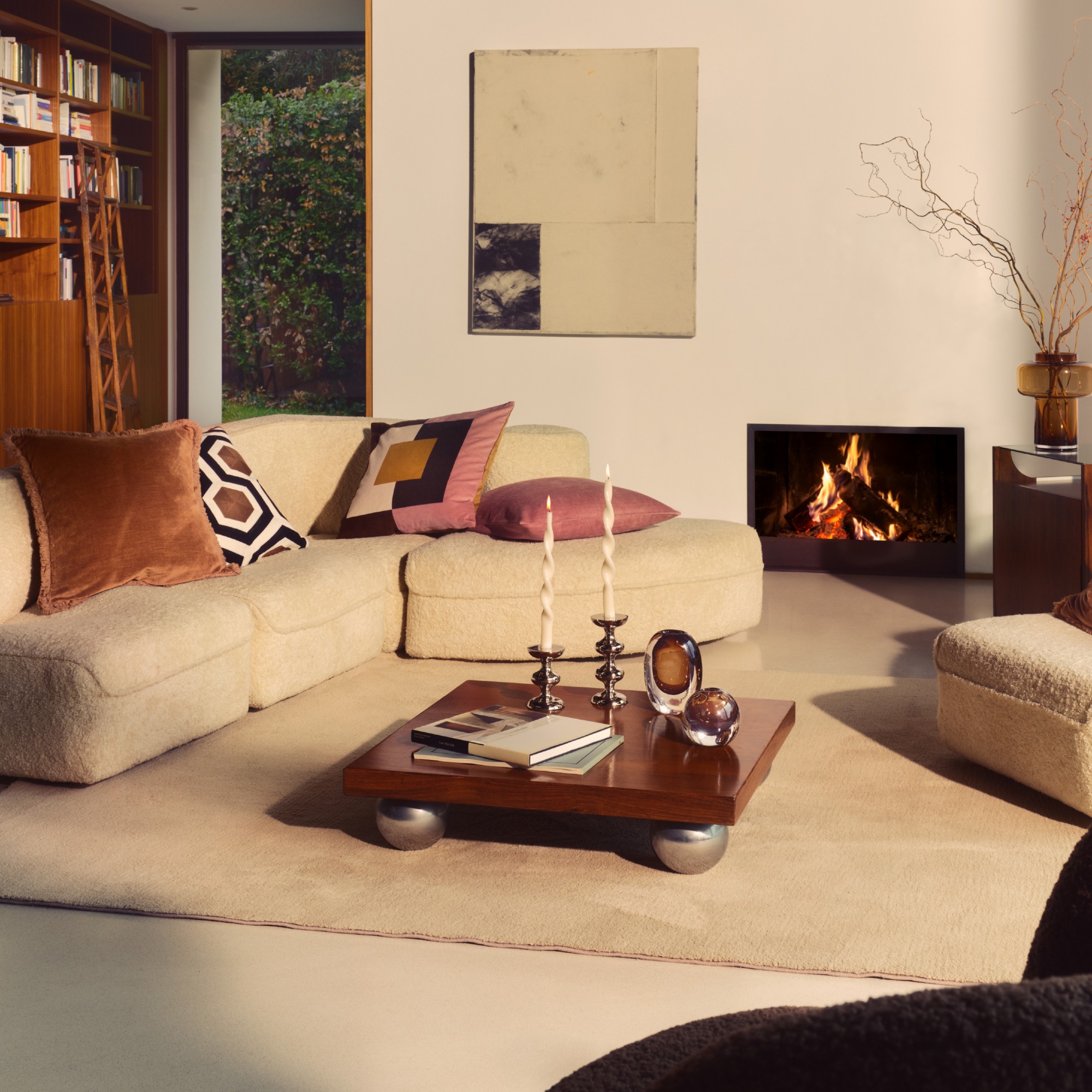 A living room with a modular sofa decorated with patterned cushions from the H&amp;M Home autumn 2025 collection