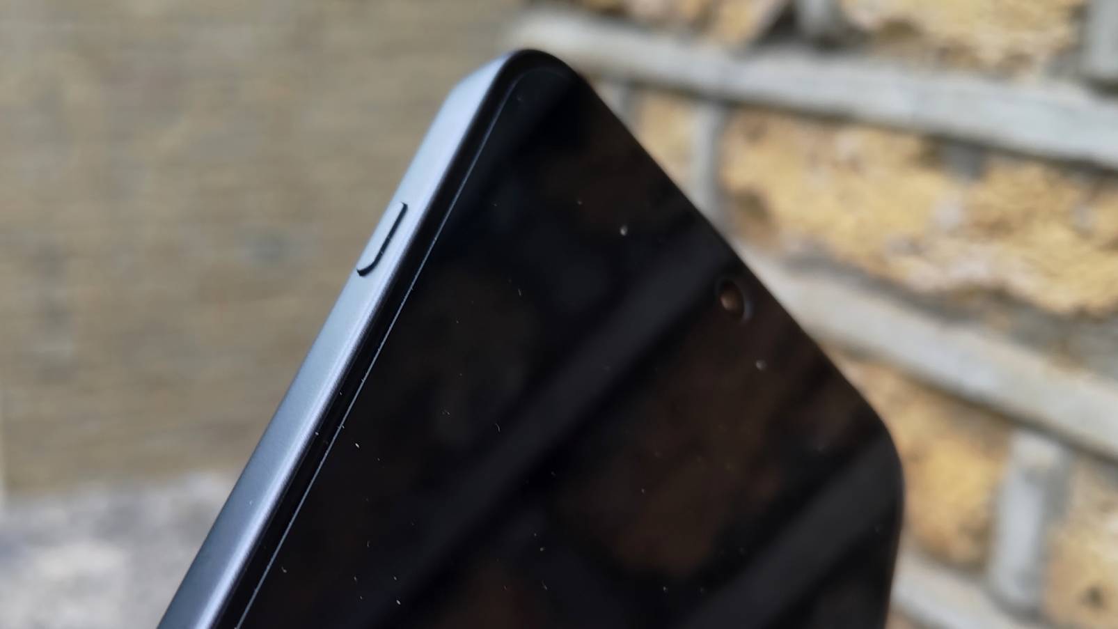 The OnePlus Nord 5 against a brick wall.