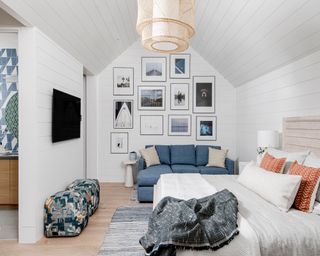 White room with blue couch, bed, and coastal decor