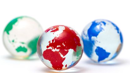 Three glass globes of the Earth, in green, red and blue.