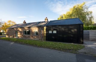 brick barn extended with metal cladding on roof and walls