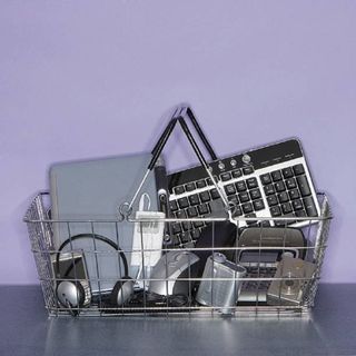 A basket of computer accessories and a laptop