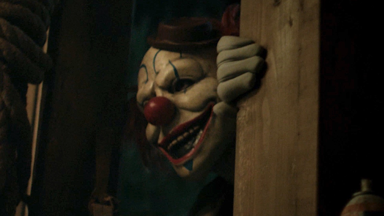 Clown poking head and hand in doorway in Clown in a Cornfield