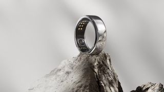 An Oura RIng generation 3 smart fitness tracker on top of a rocky landscape