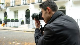 Person looking through the viewfinder of a camera, capturing the houses