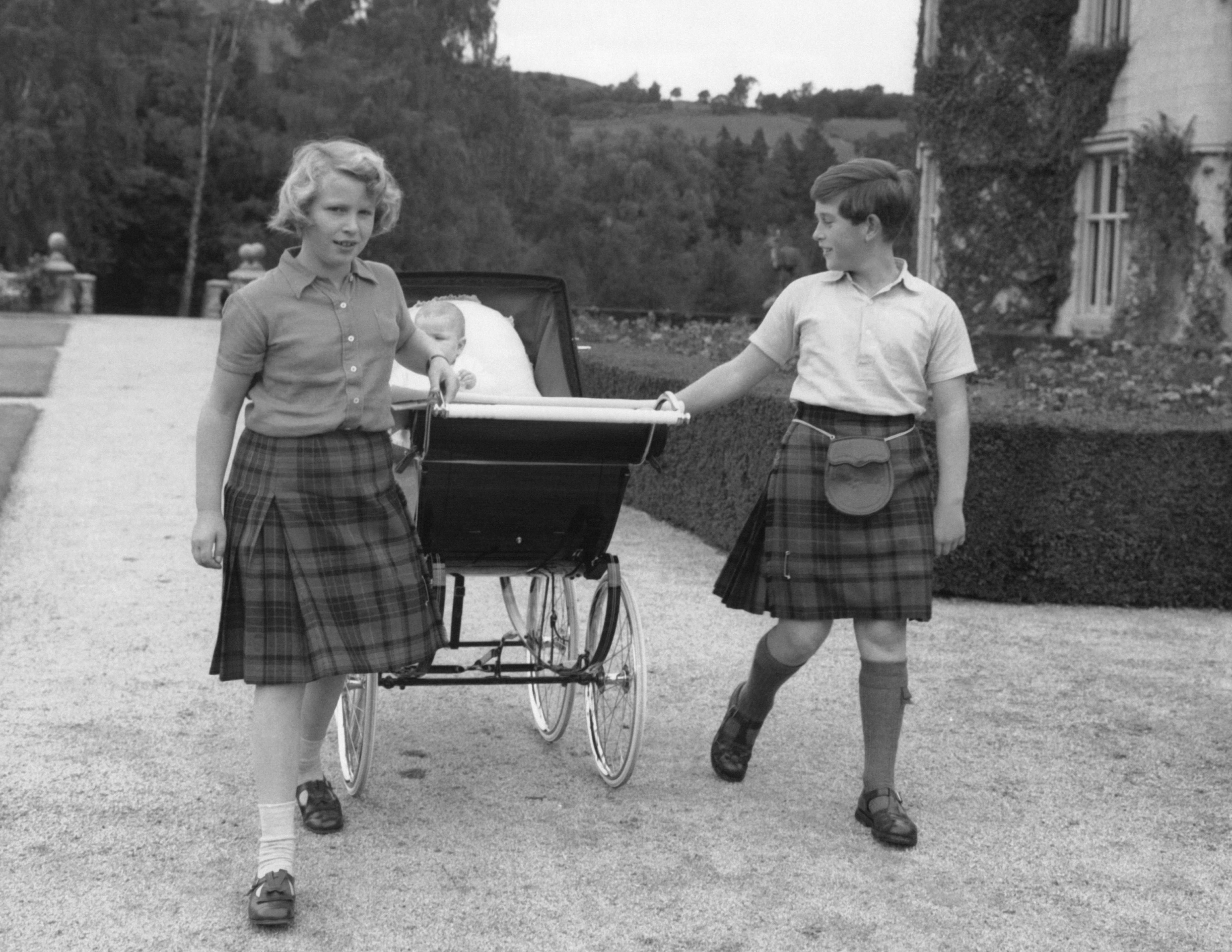 Prince Charles and Princess Anne pulling Prince Andrew in a stroller