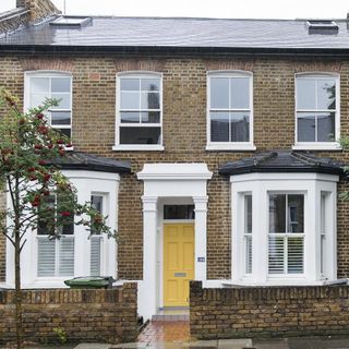 house exterior with yellow door and windows