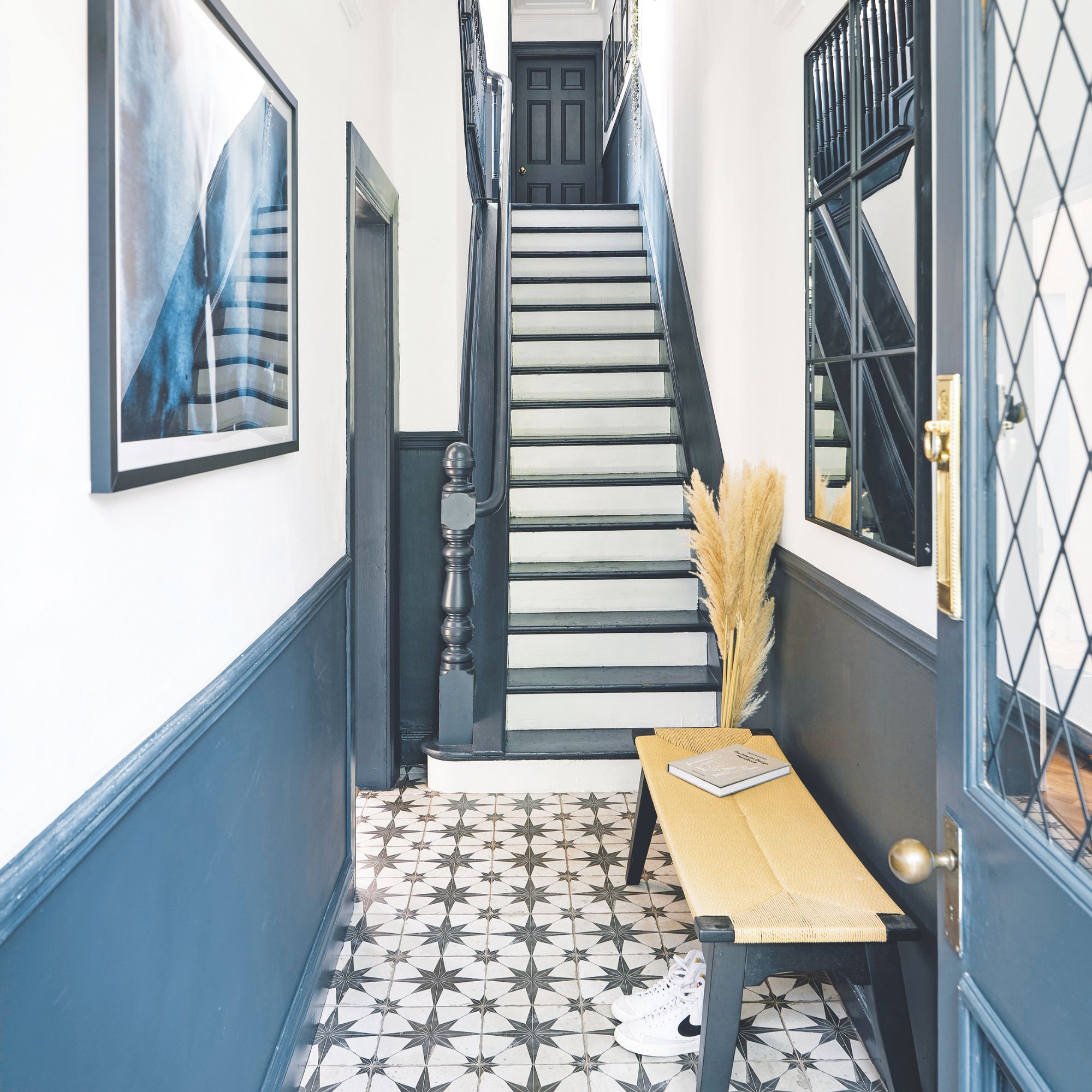 White painted hallway with blue panelling on the lower half of the wall and star patterned floor tiles