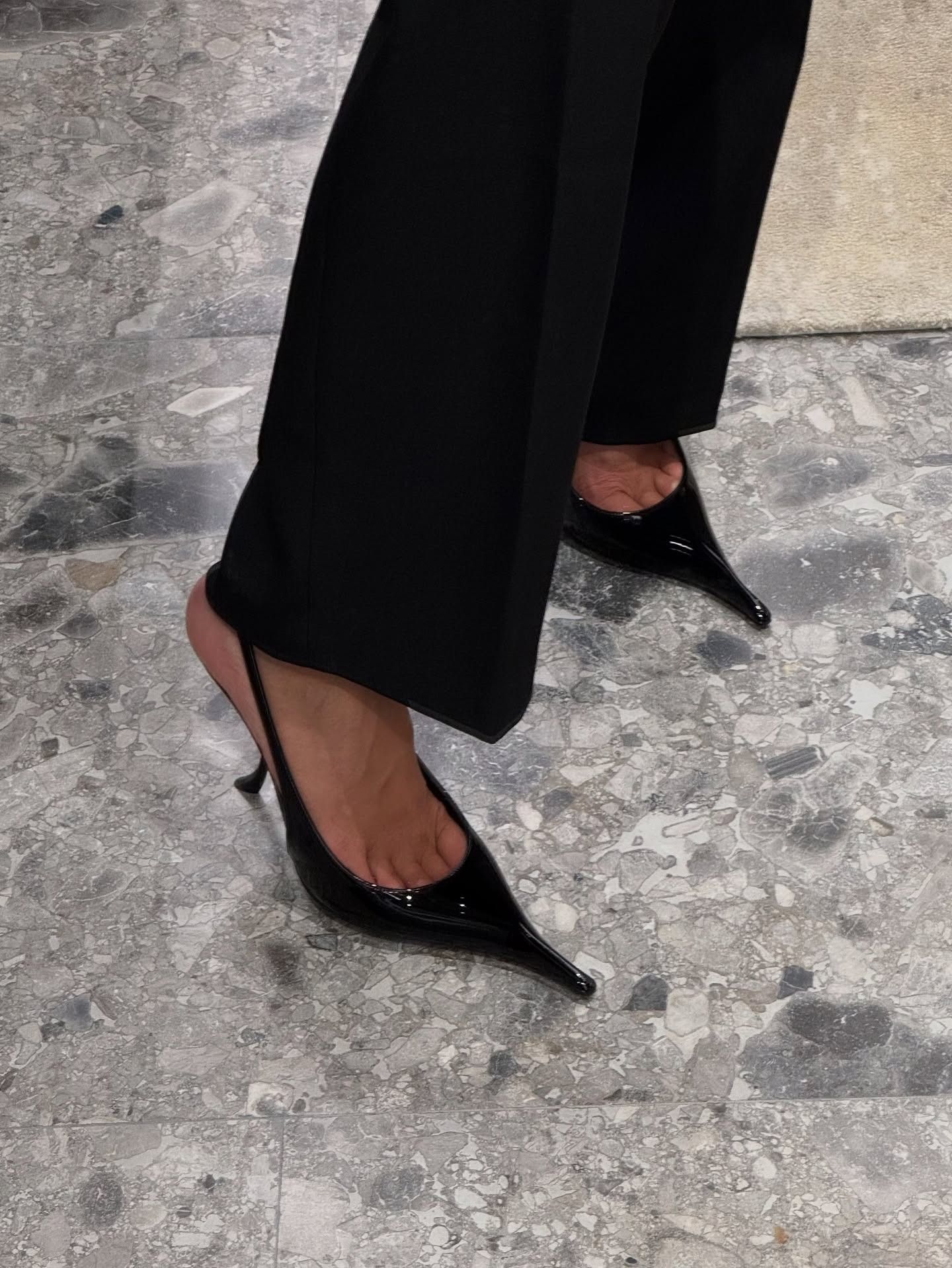 Influencer @ninasandbech wears Saint Laurent's pointed-toe slingback heels with black trousers.