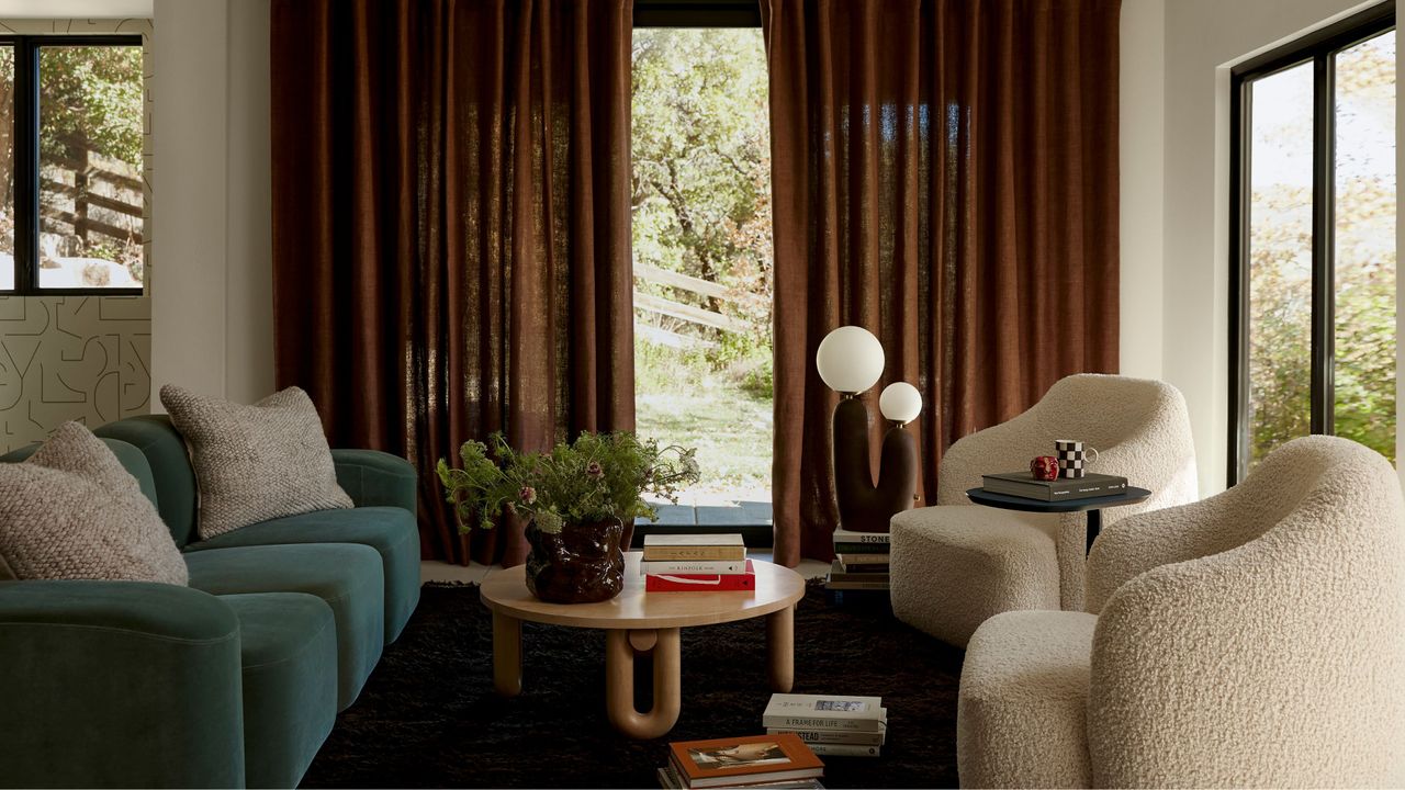 Orb lamp in living room with a blue couch and rust color curtains