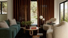 Orb lamp in living room with a blue couch and rust color curtains