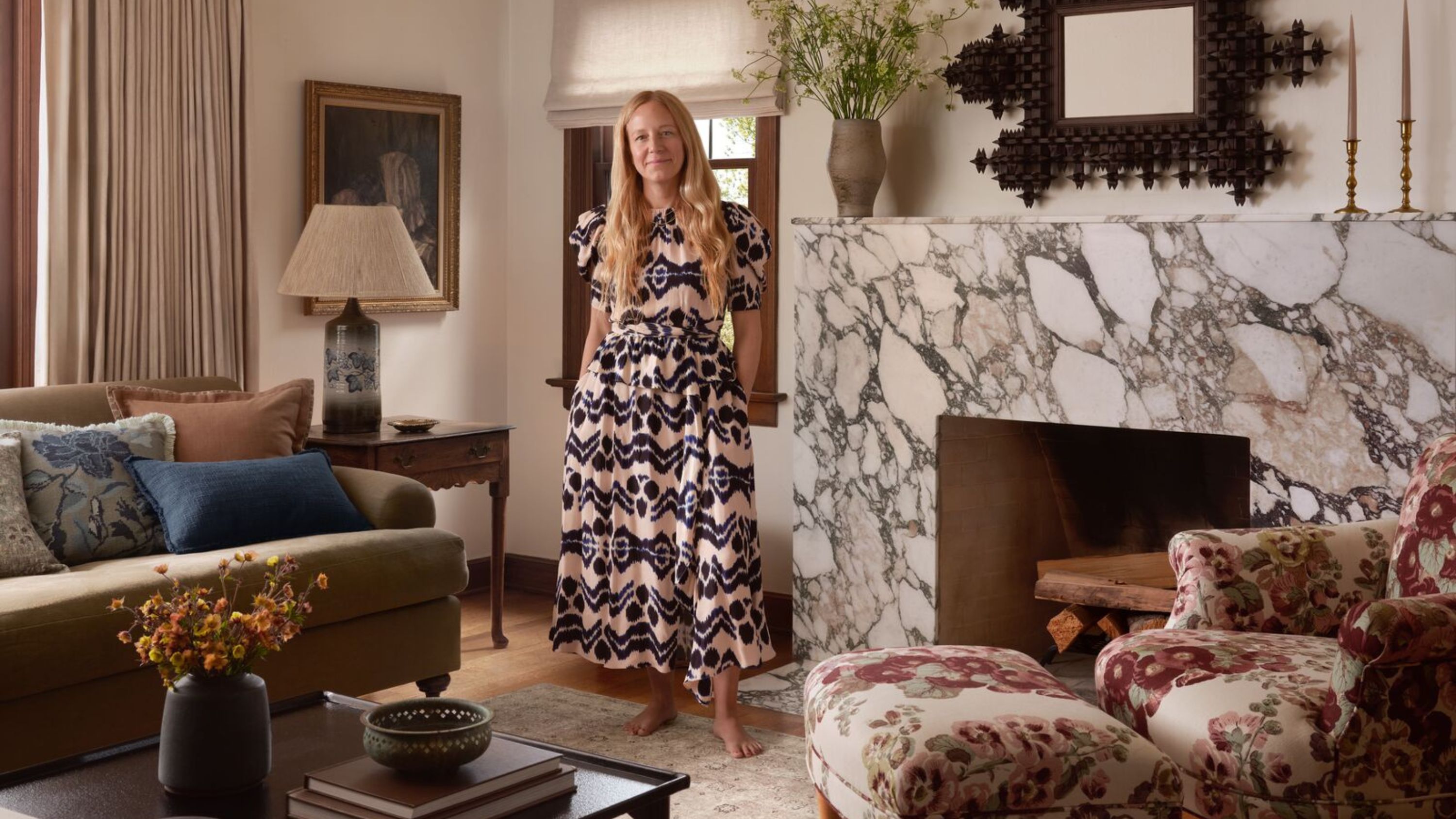 designer heidi caillier photographed for her collaboration with joon loloi in a living room with a large marble fireplace
