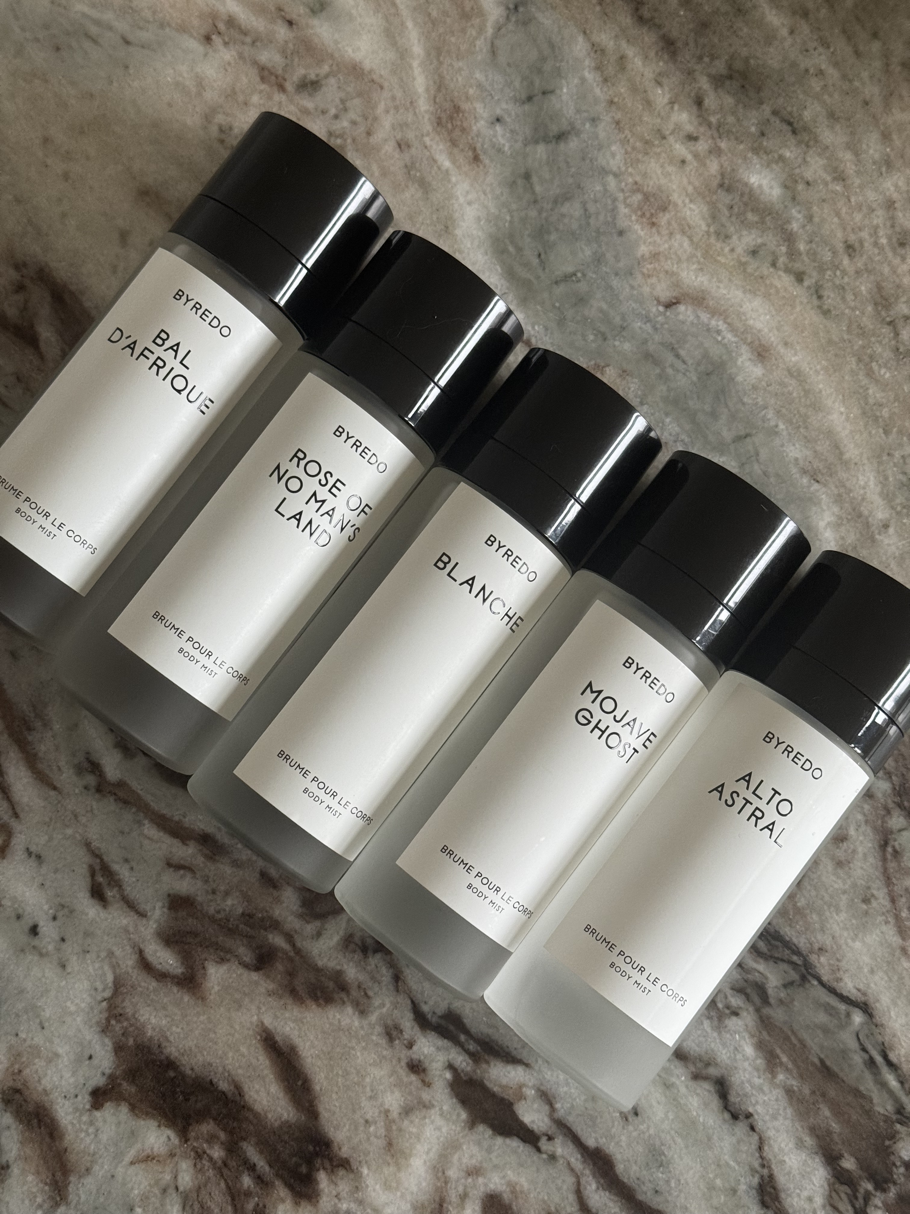 Byredo body mists on a marble table