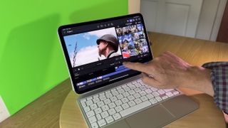 Finger touching the screen of an iPad Pro 11-inch (M4) tablet and keyboard