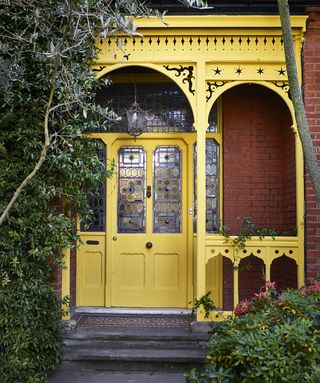Yellow painted front door and traditional terrace