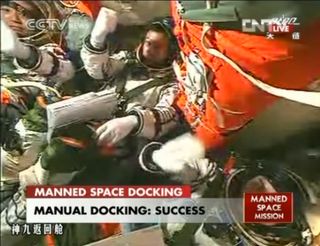 Shenzhou 9 crew celebrates manual docking at Tiangong 1 module