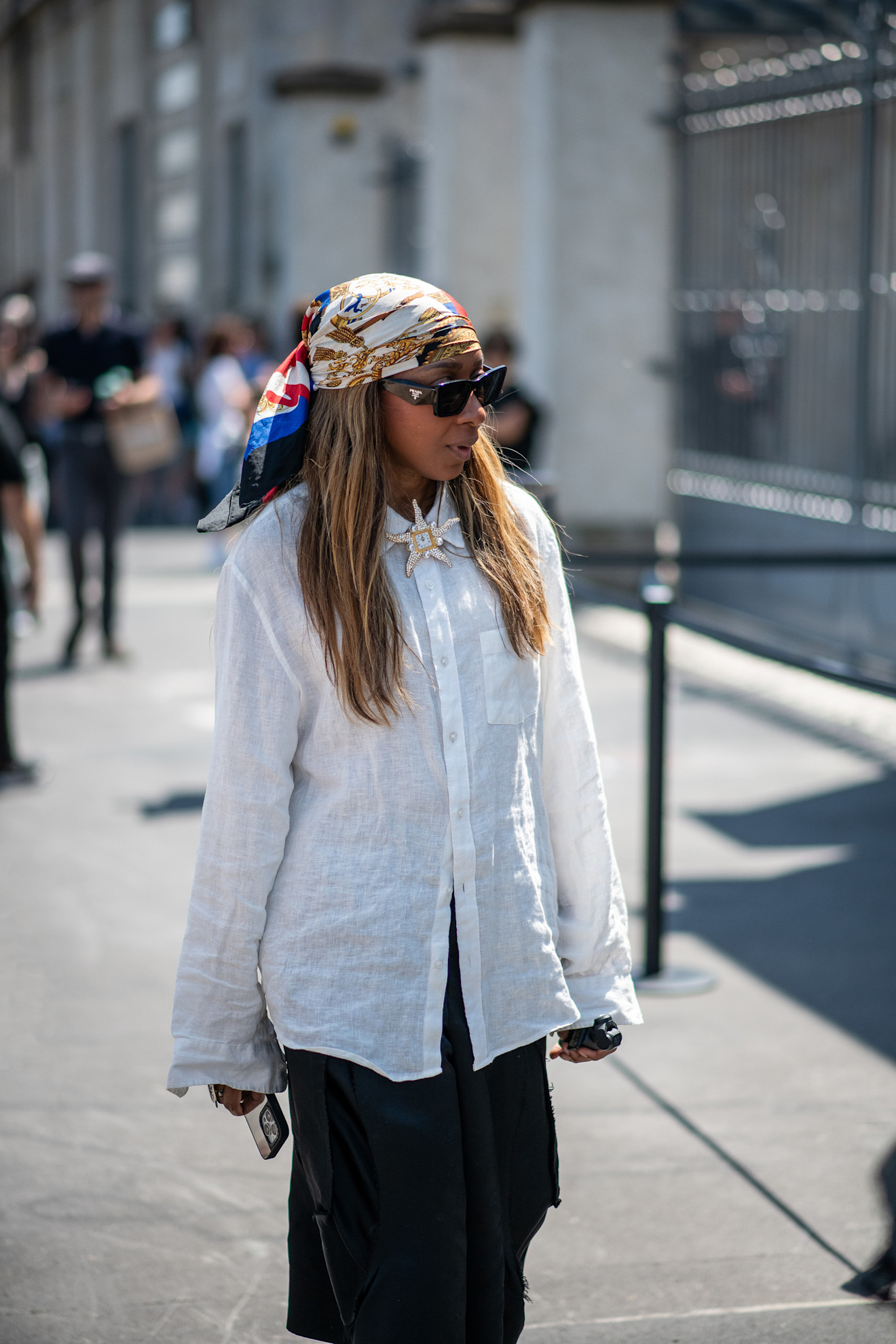 Milan Mens Fashion Week Showgoer wears a headscarf over her hair outside on the streets in Milan.