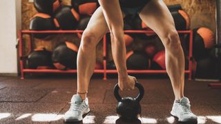 Person lifting kettlebell at gym