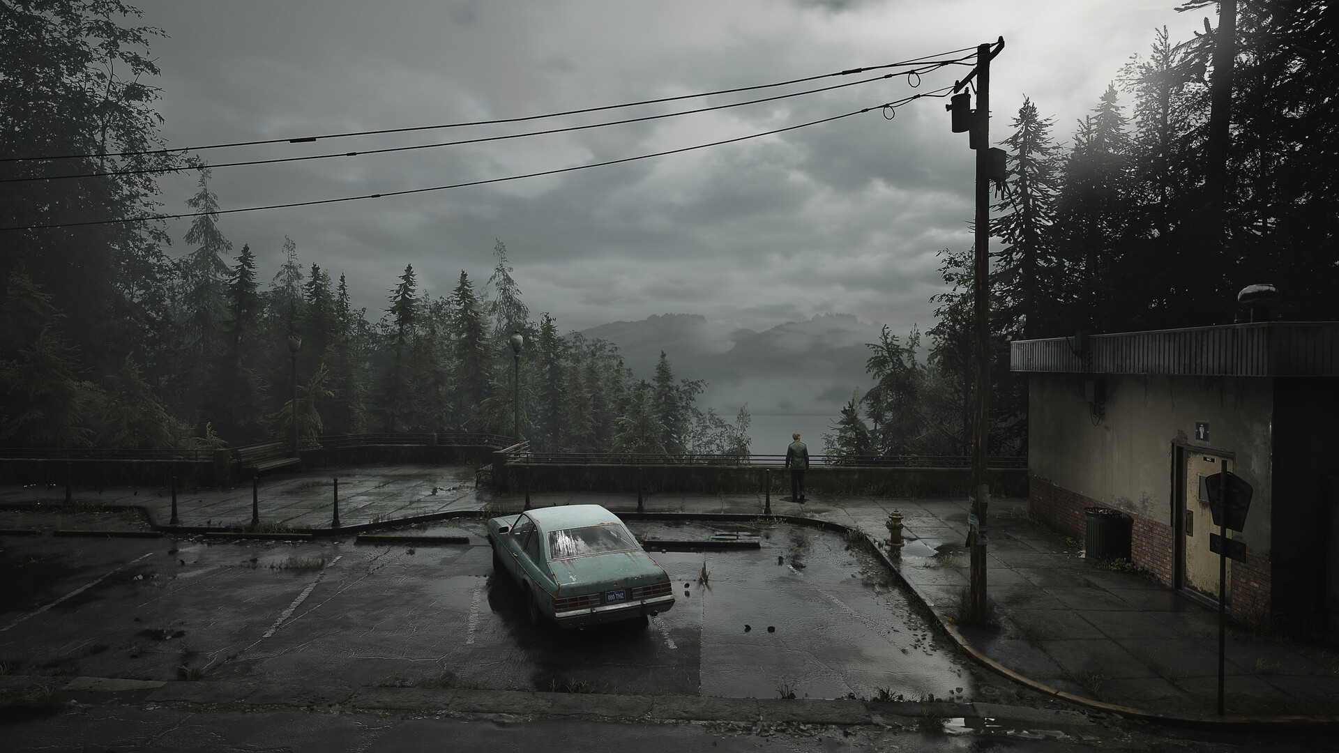 A screenshot of Silent Hill 2's main protagonist James in a car park looking out across the lake