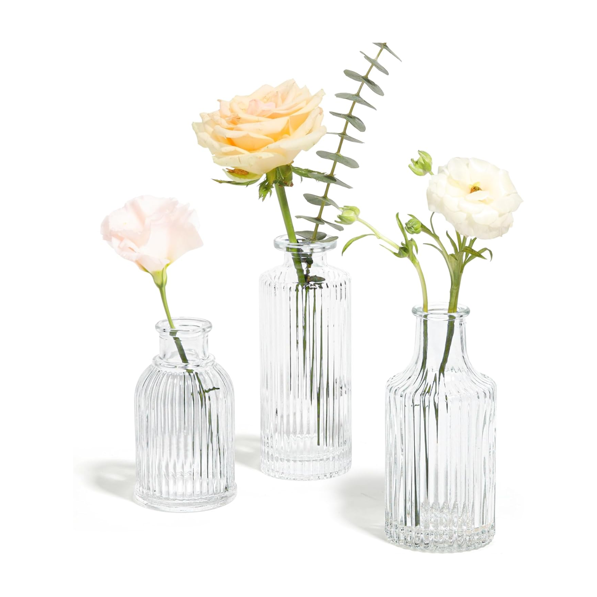 three small fluted glass flower vases holding flowers 