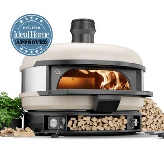 Gozney Dome outdoor oven with wood stacked in the base with the Ideal Home Approved logo