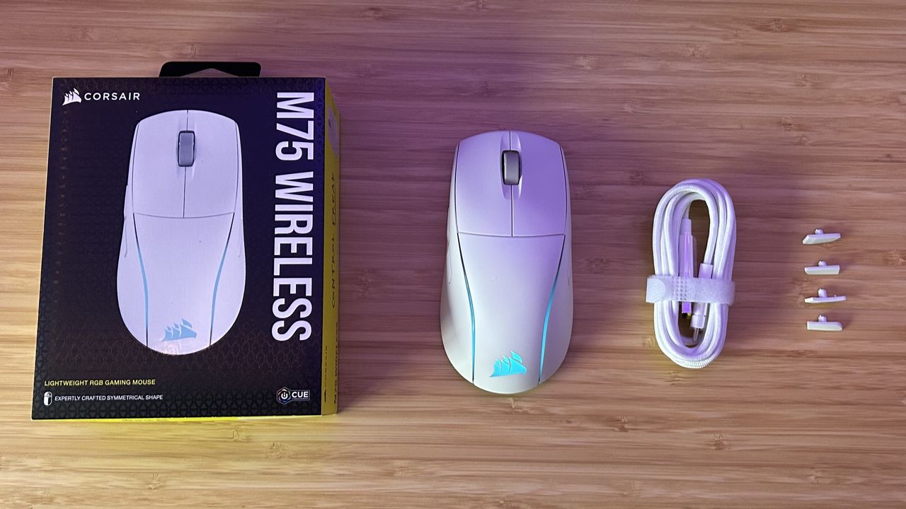 Corsair M75 Wireless with box, cable, and extra side buttons on a wooden table