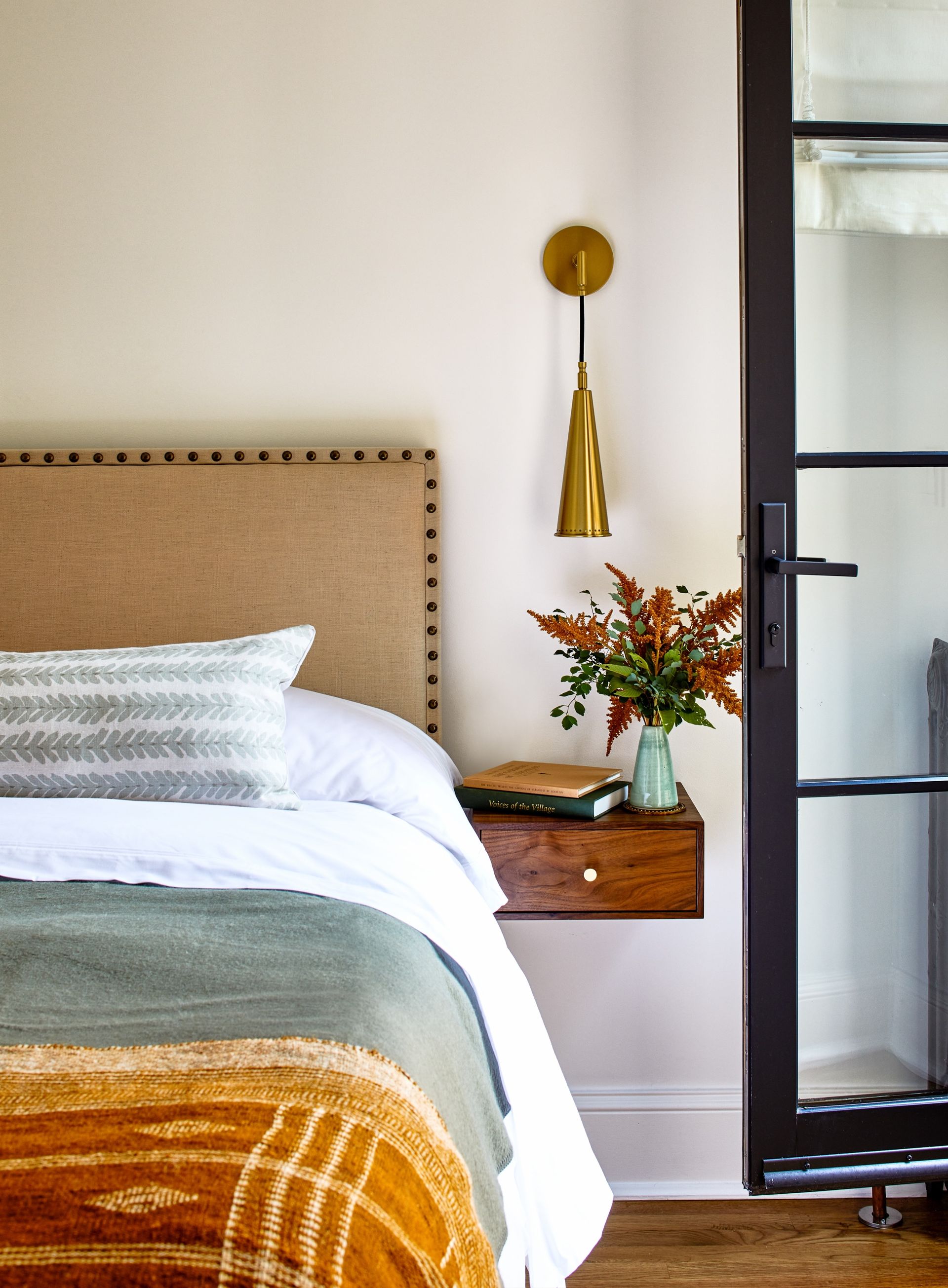 μικρό υπνοδωμάτιο με φωτιστικό τοίχου και πλωτό κομοδίνο